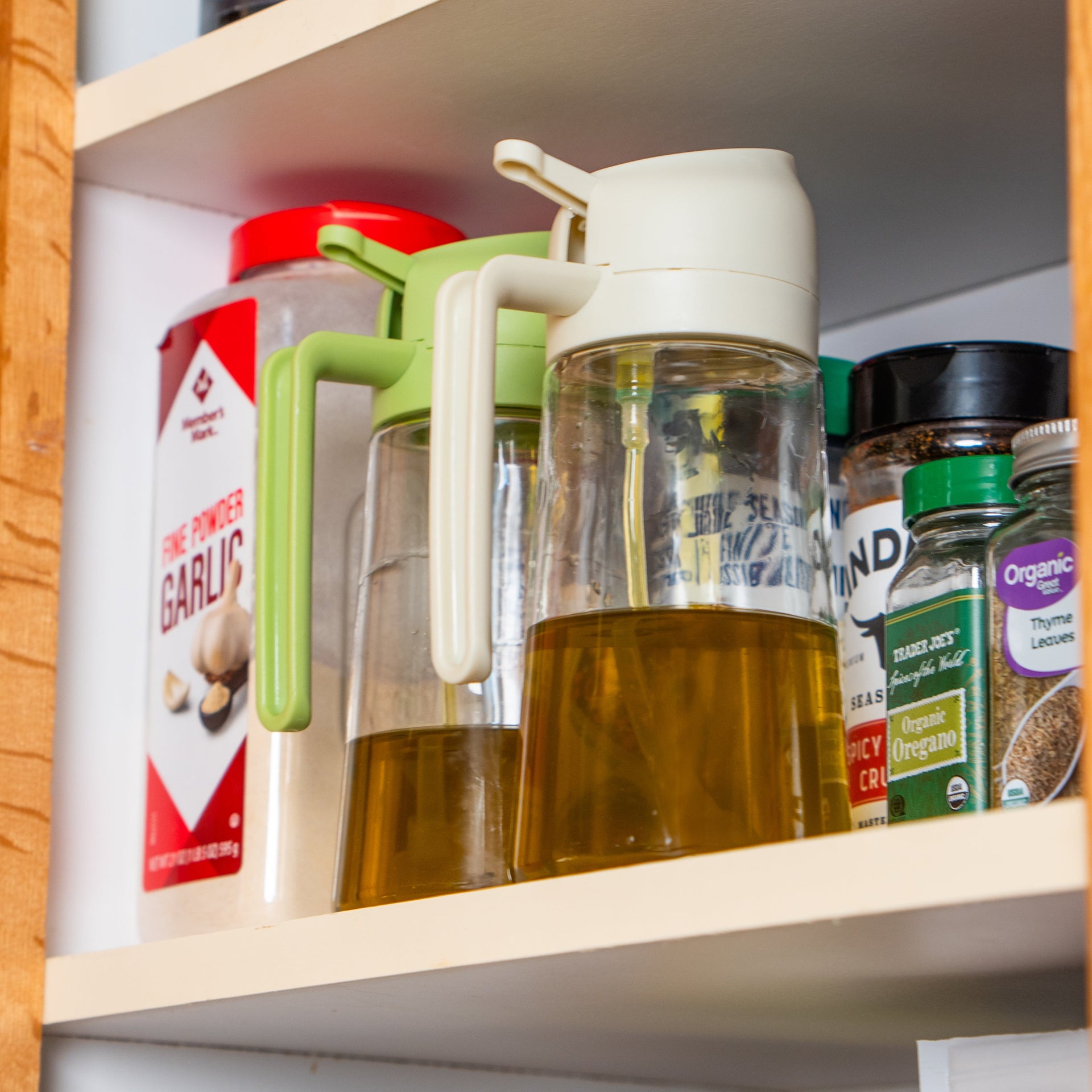 Shelf with various cooking oils and containers in a kitchen setting