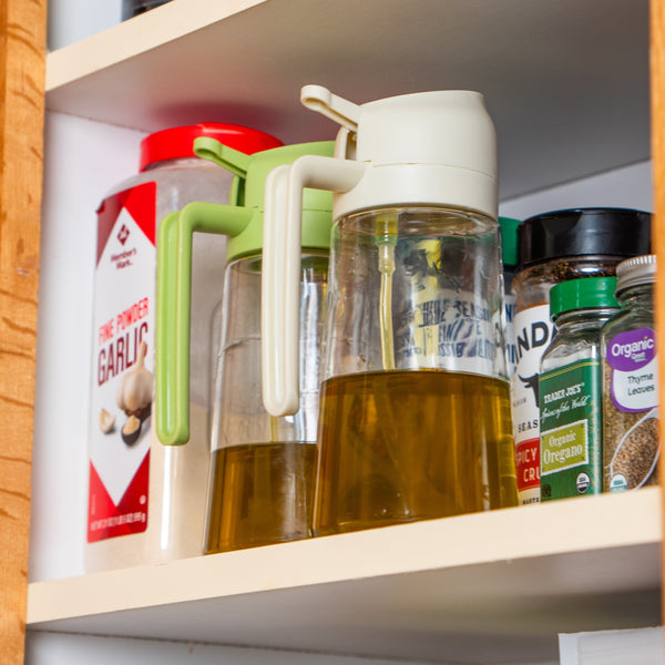 Shelf with various cooking oils and containers in a kitchen setting