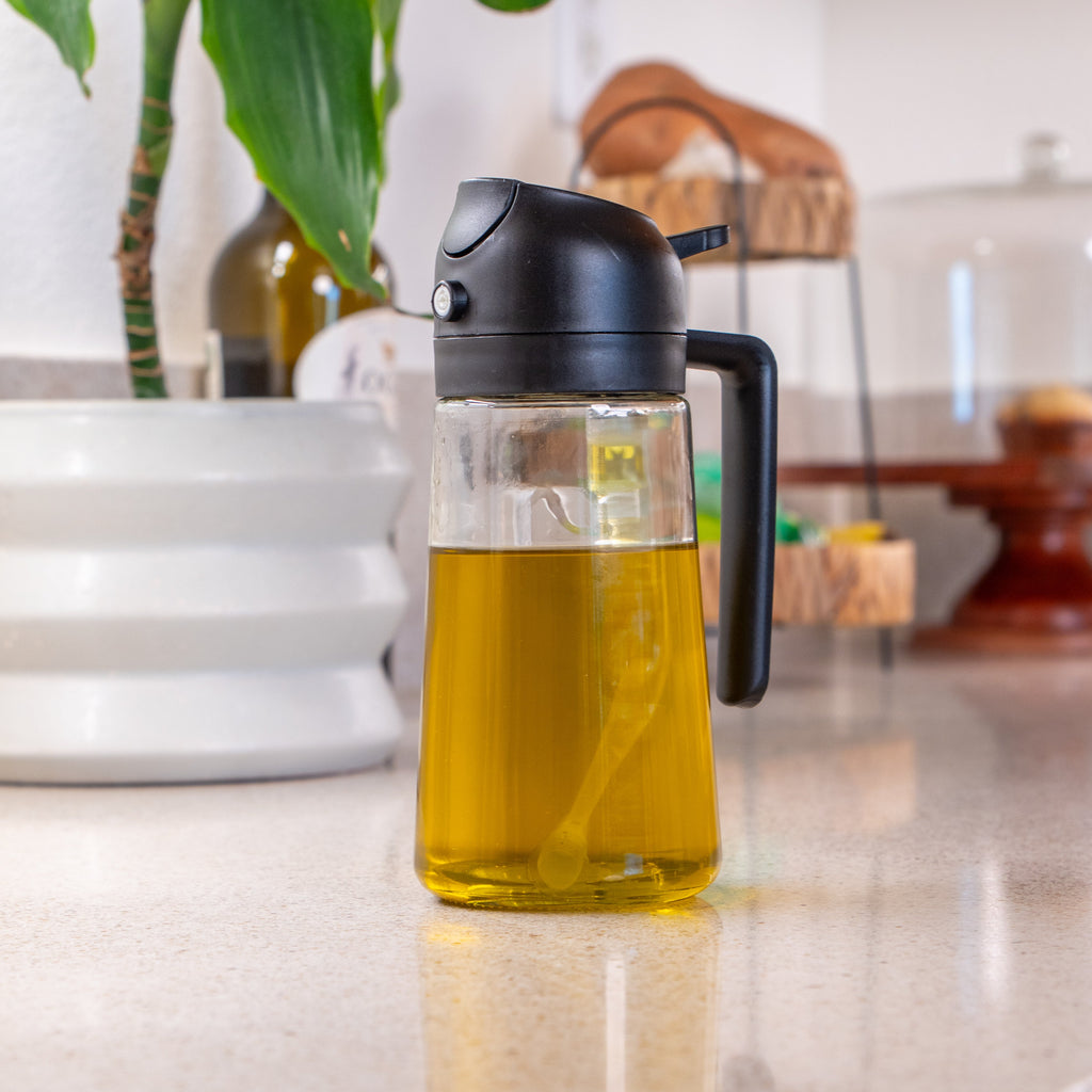 Glass bottle with black cap containing a yellow liquid on a kitchen counter.